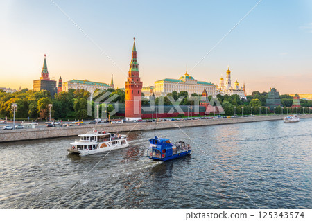 View of Kremlin with Vodovzvodnaya tower, Grand Kremlin Palace from repaired Bolshoy Kamenny Bridge in Moscow city on sunny summer day. Cruise ship sails on the Moscow river View of Kremlin with Vodovzvodnaya tower, Grand Kremlin Palace from repaired Bolshoy Kamenny Bridge in Moscow city on sunny summer day. Cruise ship sails on the Moscow river 125343574
