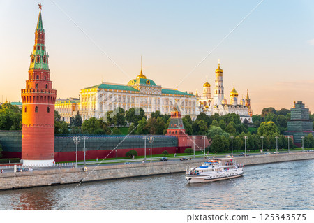 View of Kremlin with Vodovzvodnaya tower, Grand Kremlin Palace from repaired Bolshoy Kamenny Bridge in Moscow city on sunny summer day. Cruise ship sails on the Moscow river 125343575