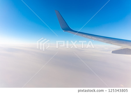 View from the airplane window at a beautiful cloudy sky and the airplane wing 125343805