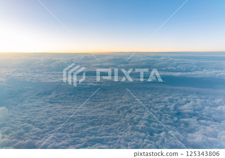 Beautiful orange and pink sunrise over the clouds, view from the plane. 125343806