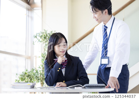 High school students studying at a cram school and their instructor High school students studying at a cram school and their instructor 125344037
