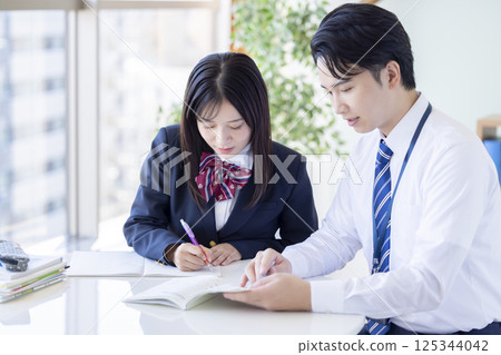 High school students studying at a cram school and their instructor High school students studying at a cram school and their instructor 125344042