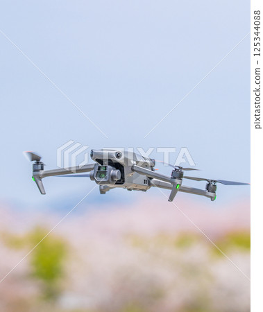 [Spring] A drone flying with cherry blossoms in the background 125344088