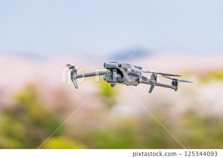 [Spring] A drone flying with cherry blossoms in the background 125344093
