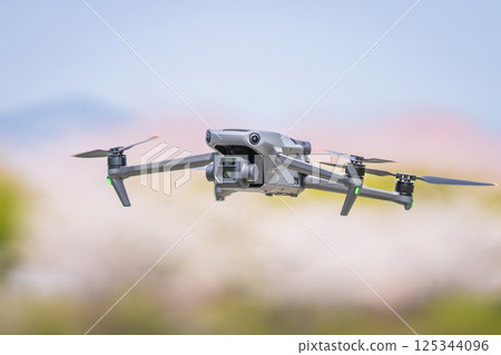 [Spring] A drone flying with cherry blossoms in the background 125344096