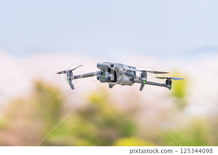 [Spring] A drone flying with cherry blossoms in the background 125344098