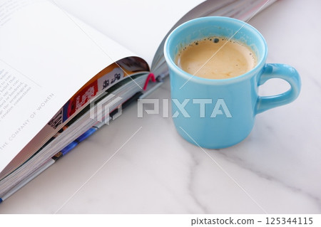 An image of enjoying reading while drinking coffee with an open book (Western book) and a coffee cup with coffee in it. 125344115