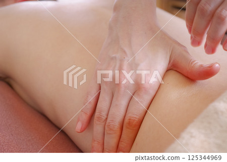 在美容院接受精油按摩的婦女 在美容院接受精油按摩的婦女 125344969