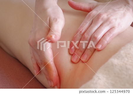 在美容院接受精油按摩的婦女 在美容院接受精油按摩的婦女 125344970