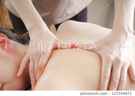 在美容院接受背部按摩的婦女 在美容院接受背部按摩的婦女 125344971