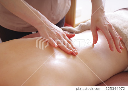 在美容院接受背部按摩的婦女 在美容院接受背部按摩的婦女 125344972