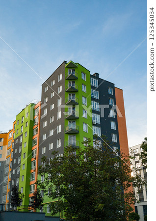 Modern multi-colored apartment building under a bright sky during late afternoon light in an urban neighborhood 125345034