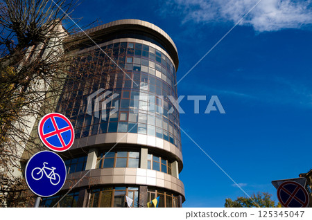 Modern architecture meets urban life in a vibrant city under a clear blue sky filled with fluffy clouds 125345047