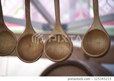 A row of handcrafted wooden spoons, showcasing the rustic charm of artisanal kitchen tools. A row of handcrafted wooden spoons, showcasing the rustic charm of artisanal kitchen tools. 125345213