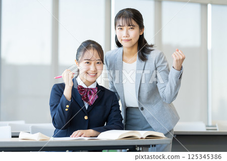 Female high school students studying at a cram school and their teacher. Photo courtesy of Denpa Gakuen, Tokyo Electronics College. 125345386