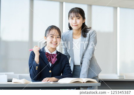 Female high school students studying at a cram school and their teacher. Photo courtesy of Denpa Gakuen, Tokyo Electronics College. Female high school students studying at a cram school and their teacher. Photo courtesy of Denpa Gakuen, Tokyo Electronics College. 125345387