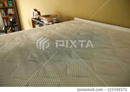 Dirty mattress pad on bed. stained and moldy protector showing signs of age and neglect, highlighting home hygiene, health risks, and the need for replacement or cleaning 125348373