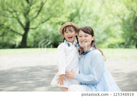 家長和孩子看著鏡頭,為孩子戴上降溫圈,抵禦夏日酷暑 家長和孩子看著鏡頭,為孩子戴上降溫圈,抵禦夏日酷暑 125348919