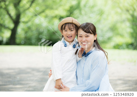 家長和孩子看著鏡頭,為孩子戴上降溫圈,抵禦夏日酷暑 家長和孩子看著鏡頭,為孩子戴上降溫圈,抵禦夏日酷暑 125348920