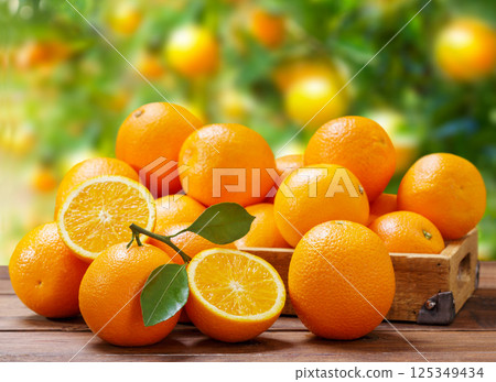 wooden box of fresh orange fruits on table on garden background wooden box of fresh orange fruits on table on garden background 125349434