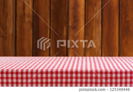 Empty red and white checkered tablecloth on wooden background 125349446