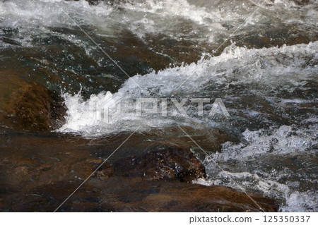 The Yu River, Yu Kawa, in Karuizawa, Nagano prefecture Japan near the Hoshino Resort with rocks stained white from the hot springs The Yu River, Yu Kawa, in Karuizawa, Nagano prefecture Japan near the Hoshino Resort with rocks stained white from the hot springs 125350337