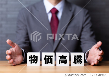 Blocks of rising prices and a middle-aged male businessman wearing a suit 125350983