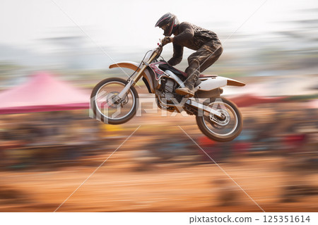 Dynamic composition with a motorcycle racer participating in motocross freestyle Dynamic composition with a motorcycle racer participating in motocross freestyle 125351614