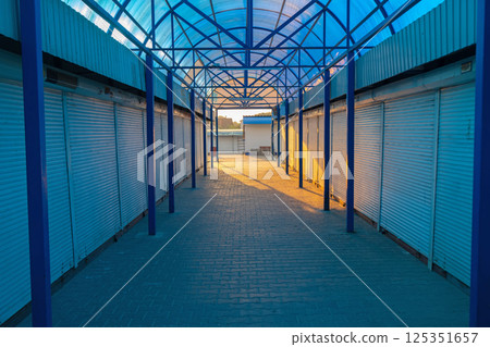 Empty closed unmanned commercial metal roller shutters on the modern market. 125351657