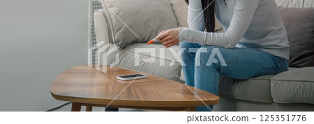 A sad woman holds a pregnancy test in her hand. Unwanted pregnancy concept. A sad woman holds a pregnancy test in her hand. Unwanted pregnancy concept. 125351776