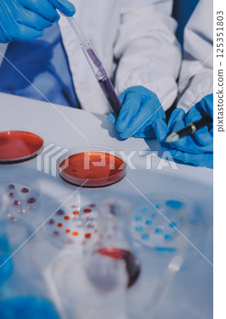 Researcher using a professional microscope 125351803