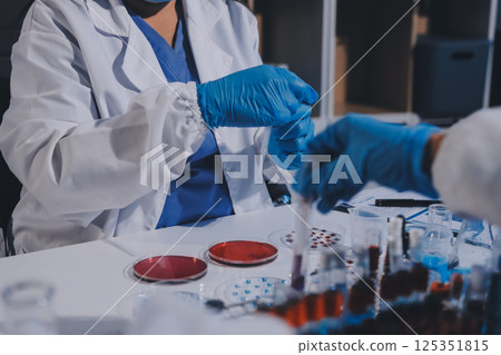 Researcher using a professional microscope 125351815