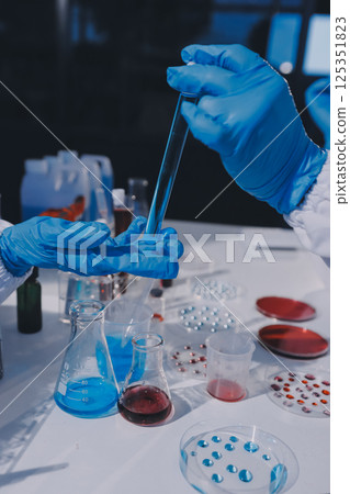 Researcher using a professional microscope Researcher using a professional microscope 125351823