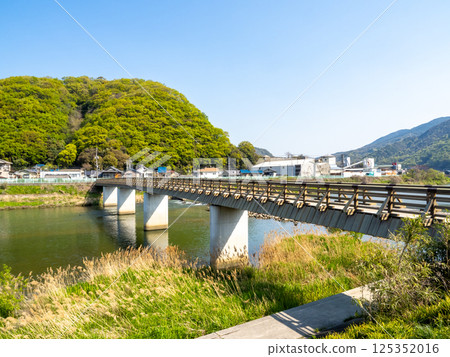 Shinkoji Bridge with the mountain across the river covered in fresh greenery 125352016
