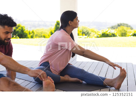 Family enjoying outdoor yoga session on deck, stretching and relaxing together Family enjoying outdoor yoga session on deck, stretching and relaxing together 125352151