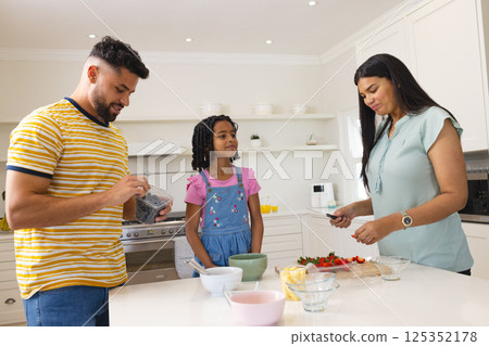 In kitchen, family preparing breakfast together, sharing quality time and fresh fruit 125352178