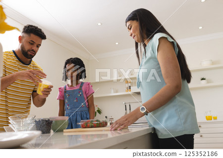 Family preparing dessert together in kitchen, enjoying quality time and bonding 125352186
