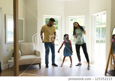 Family dancing together in living room, enjoying quality time and laughter Family dancing together in living room, enjoying quality time and laughter 125352215