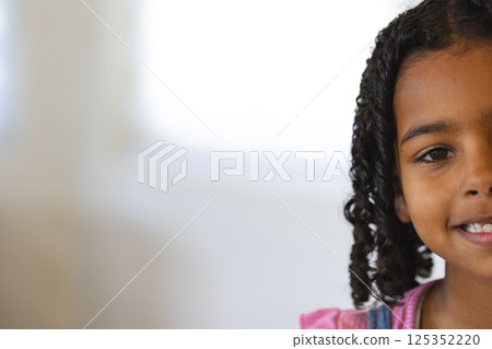 Smiling child with curly hair enjoying playful moment at home, copy space Smiling child with curly hair enjoying playful moment at home, copy space 125352220