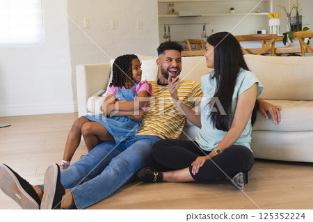 Happy family sitting on living room floor, enjoying quality time together 125352224