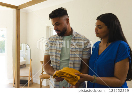 Couple organizing clothes at home, collaborating on household chores together Couple organizing clothes at home, collaborating on household chores together 125352239