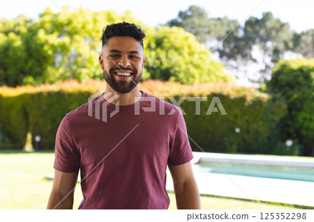 Smiling man enjoying sunny day in backyard garden near swimming pool Smiling man enjoying sunny day in backyard garden near swimming pool 125352298