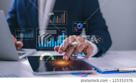 Businessman using laptop and tablet to analyze business data, Database and indicators, Business data dashboard, Company growth goals, Development, marketing and sales, Data management system with KPI. 125352376