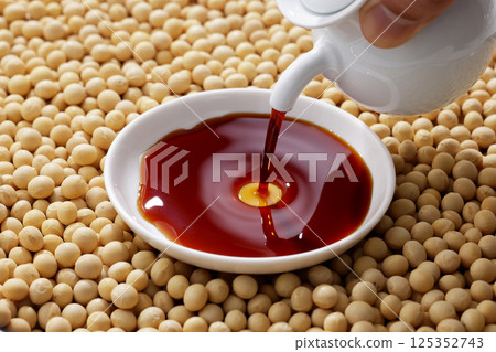 將黃豆和醬油倒入碗中 將黃豆和醬油倒入碗中 125352743