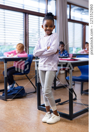 In school, african american girl standing in classroom with diverse classmates studying, copy space In school, african american girl standing in classroom with diverse classmates studying, copy space 125352960