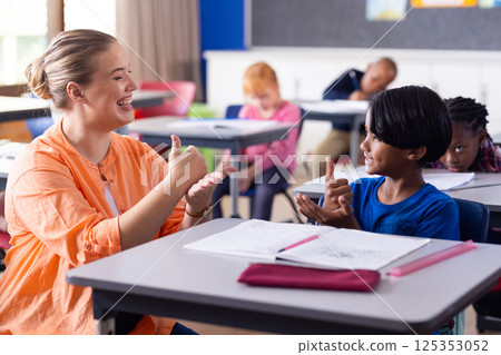 Using sign language, female teacher and boy engaging in communication at school Using sign language, female teacher and boy engaging in communication at school 125353052