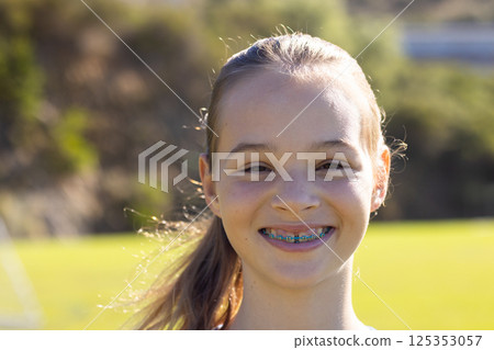 Smiling girl with braces enjoying outdoor time at school playground 125353057
