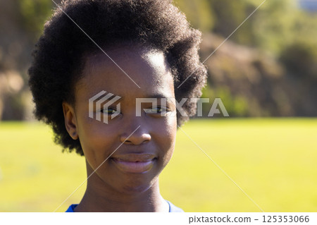 Smiling african american girl outdoors in school uniform, enjoying sunny day at school 125353066
