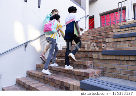 Diverse students with backpacks walking up stairs to school, heading to class Diverse students with backpacks walking up stairs to school, heading to class 125353187