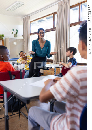 Engaging with students in classroom, indian female teacher in school smiling and interacting 125353285